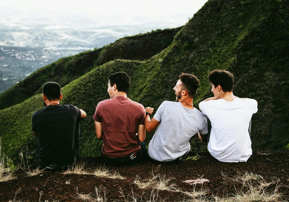 Four friends enjoying a scenic mountain view, symbolizing friendship and adventure.